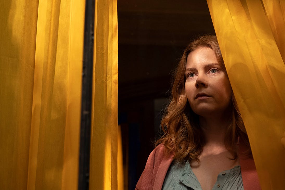 a woman stares out from a window.